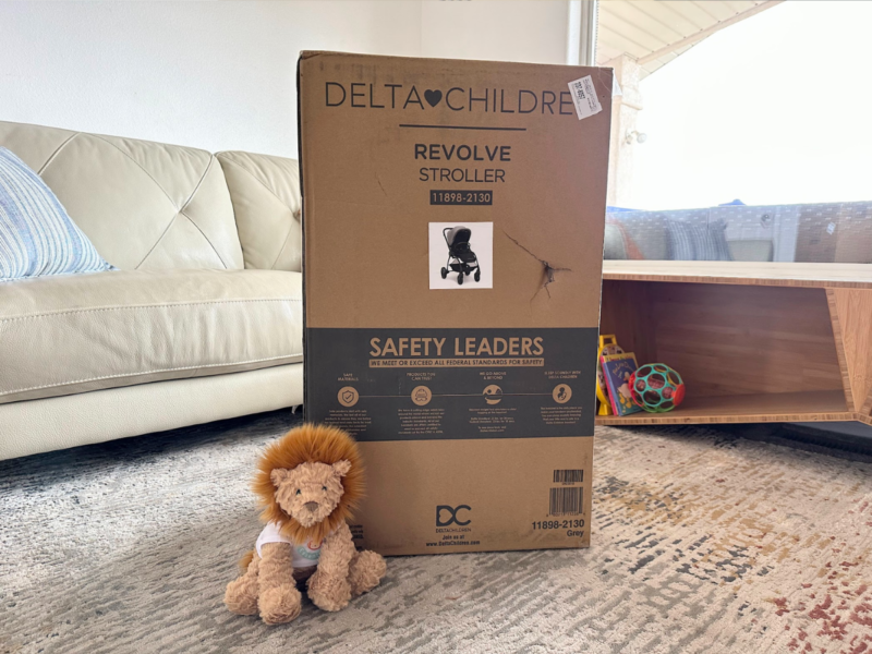 Delta Children Revolve Stroller in the box with the Baby Gear Essentials Lion