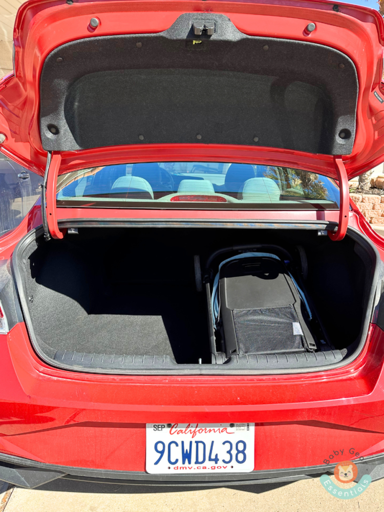 Thule Shine Stroller folded in trunk of red car